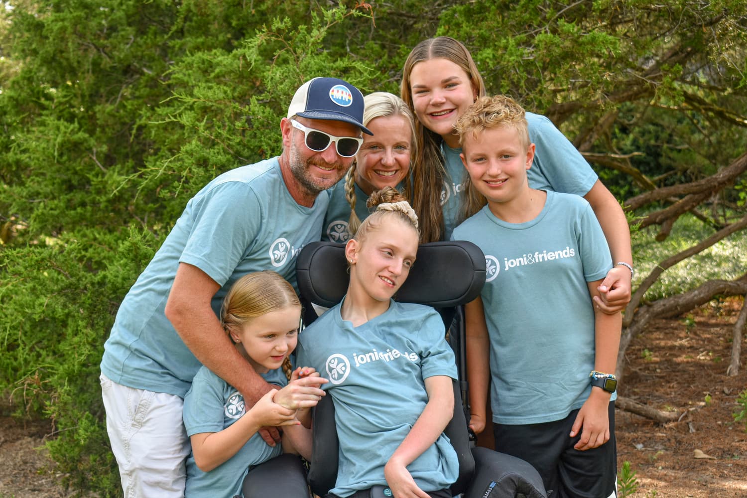 A girl in a wheelchair surrounded by her siblings and parents, all wearing Joni and Friends t-shirts.