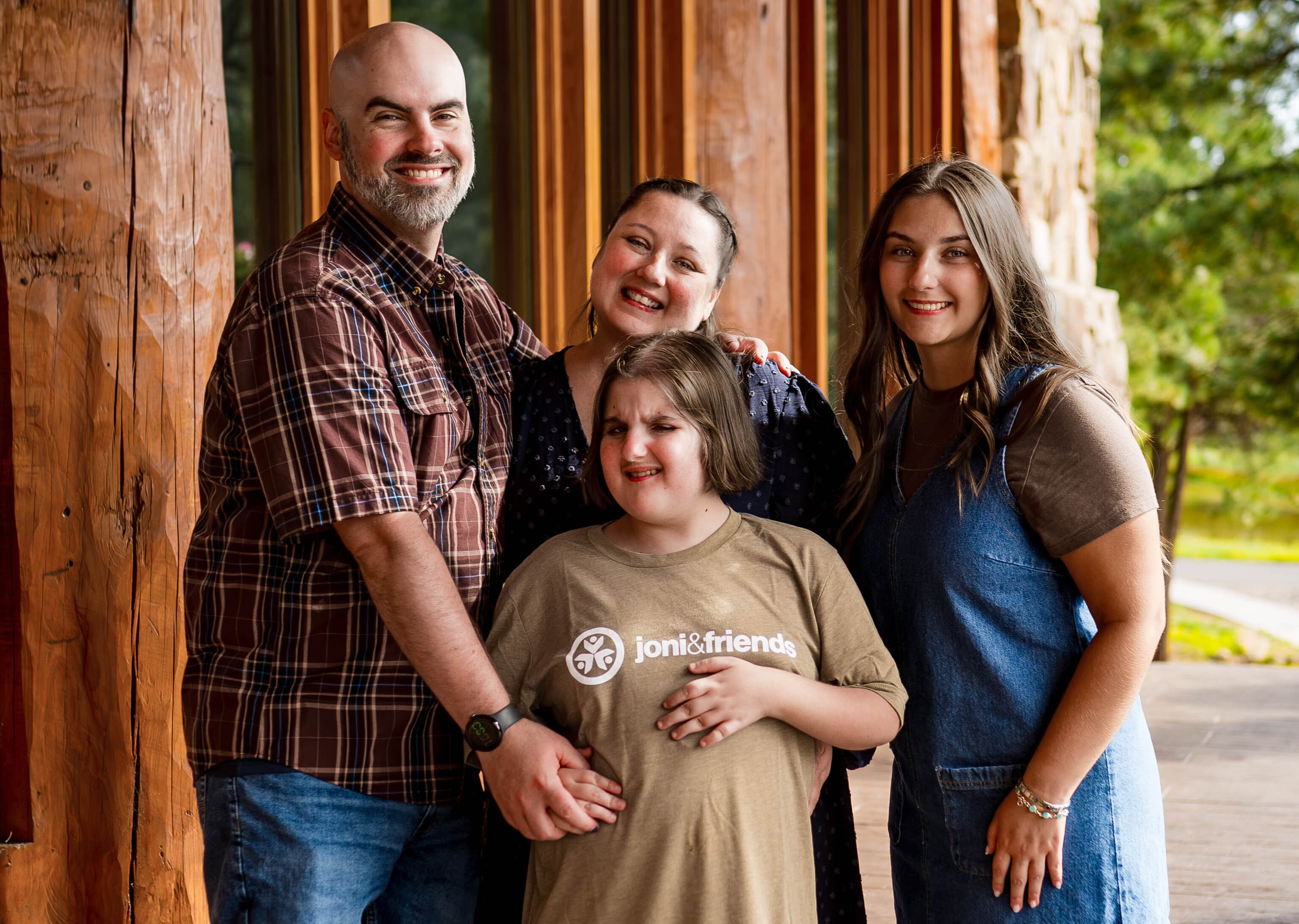 A family of four smiling and posing for the camera.